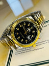 Luxury men's two-tone gold and silver watch with black dial and diamond markers on display
