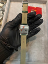 Luxury men's wristwatch with leather strap and Cartier branding, held by a gloved hand.