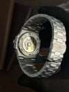 Luxury men's stainless steel watch with open case back, showing automatic movement