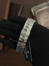 Stainless steel Patek Philippe men's watch bracelet displayed on gloved hand, luxury watch accessory.