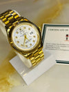 Gold men’s luxury watch with white dial and date display on marble, certificate behind. Premium men’s watches at Ministry of Mens Affair.